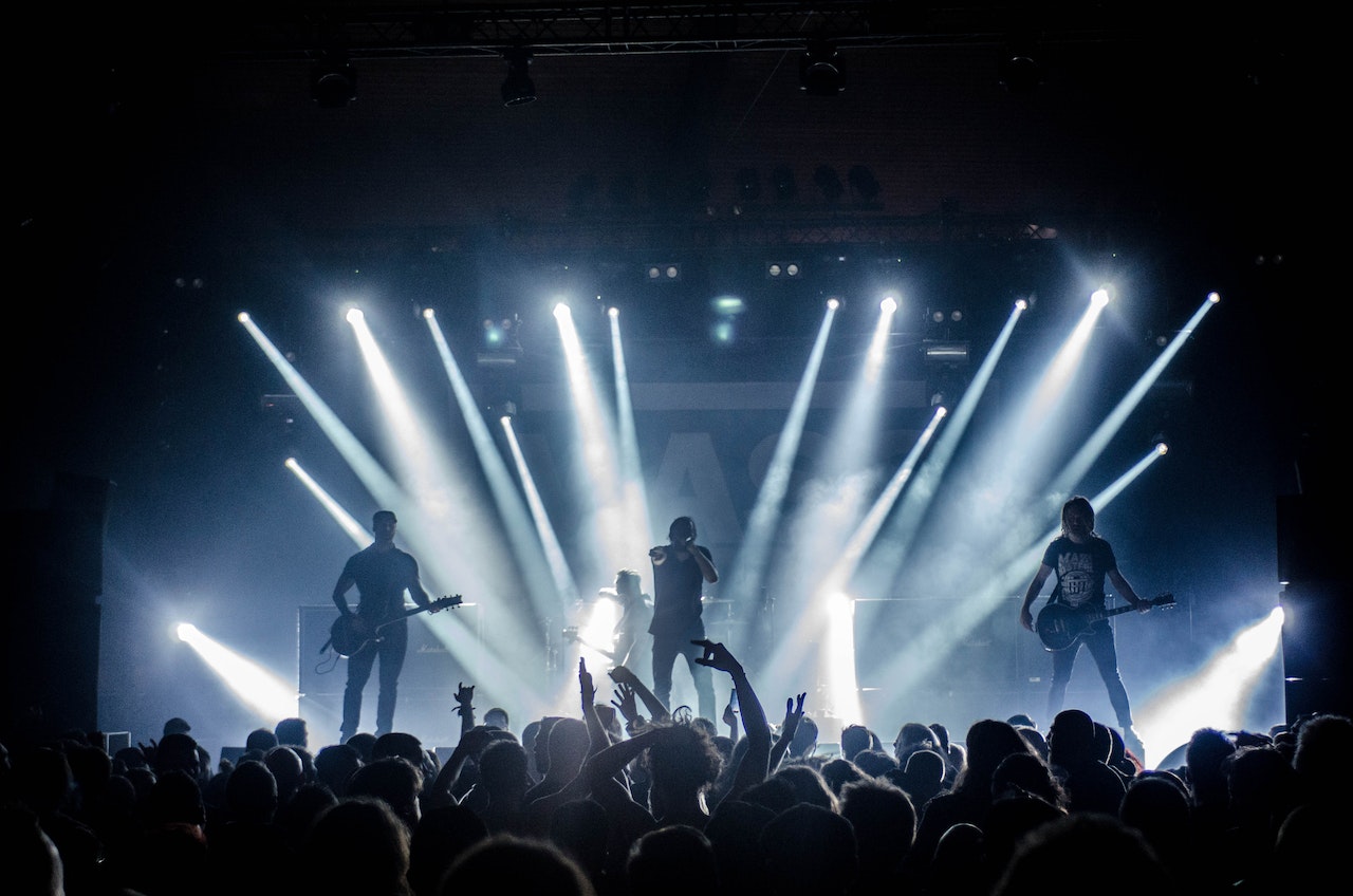 Band performing at a live music concert with lights